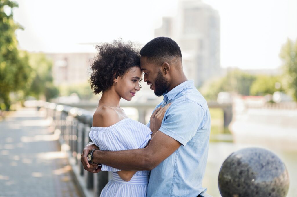 Loving african-american couple hugging on the bridge
