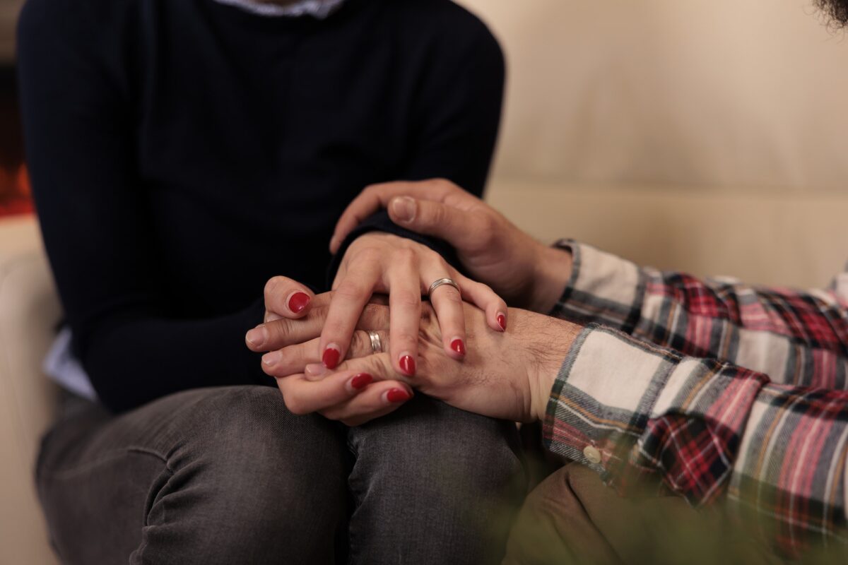 Life partners holding hands at couple therapy session